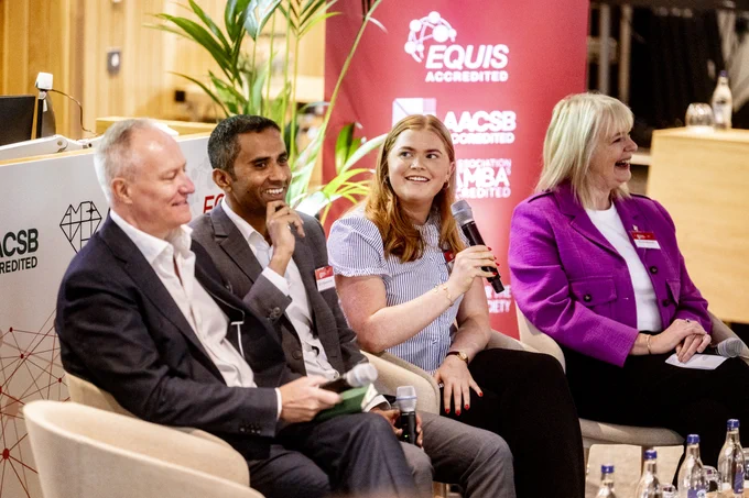 Image shows some of the panellists at the event. One of them is holding a microphone and they are all smiling.