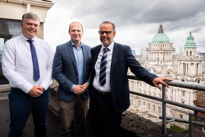 Minister Lyons photographed with representatives from the National Housing Building Council, with City Hall in the background.