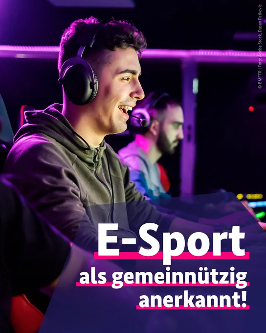 Zwei Personen beim Computerspielen in einem dunklen Raum, mit dem auf dem Bild eingeblendeten Text: "E-Sport als gemeinnützig anerkannt!"