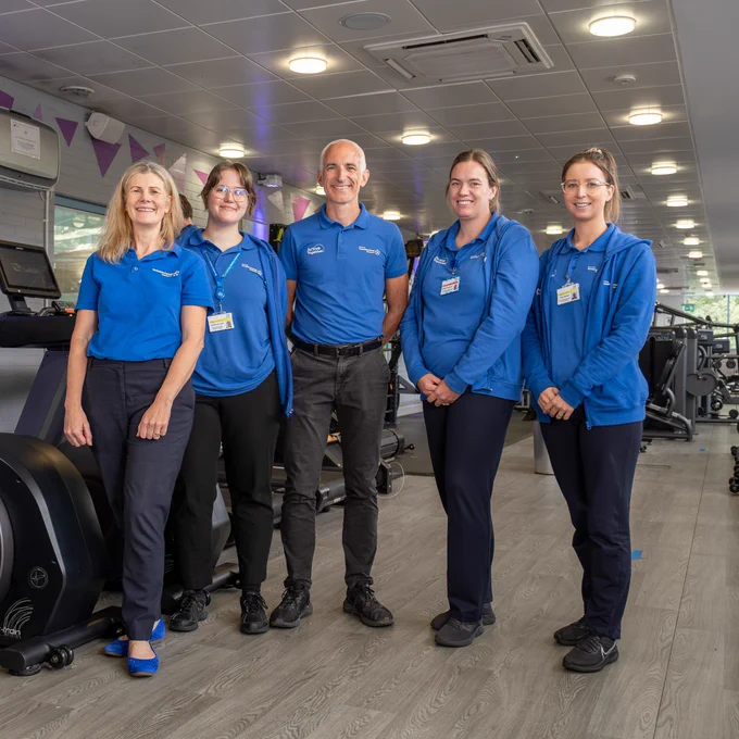The Active Together team in Airedale stand in a gym setting wearing Yorkshire Cancer Research branded polo shirts