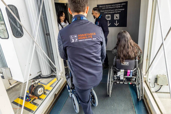 Héritage des Jeux, la possibilité offerte aux voyageurs qui le souhaitent de conserver leur fauteuil roulant personnel tout au long de leur parcours en aérogare pour ainsi préserver leur confort et leur autonomie. 