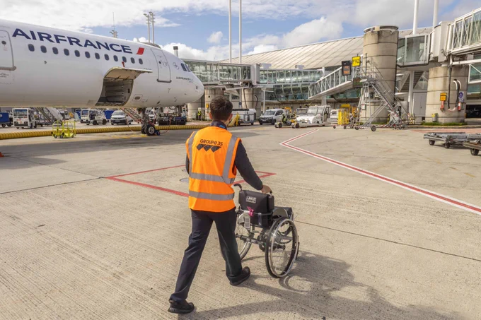 Héritage des Jeux, la possibilité offerte aux voyageurs qui le souhaitent de conserver leur fauteuil roulant personnel tout au long de leur parcours en aérogare pour ainsi préserver leur confort et leur autonomie. 