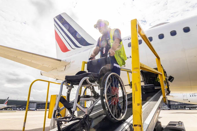 Héritage des Jeux, la possibilité offerte aux voyageurs qui le souhaitent de conserver leur fauteuil roulant personnel tout au long de leur parcours en aérogare pour ainsi préserver leur confort et leur autonomie. 