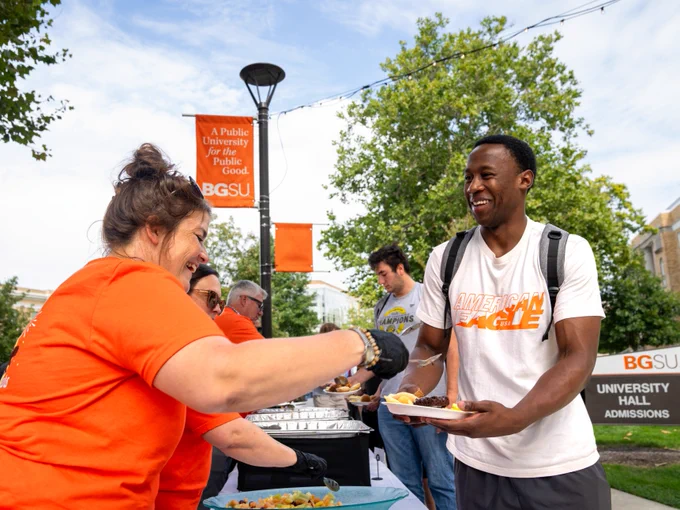 Person receiving food from a server at the BGSU All-Campus Picnic.