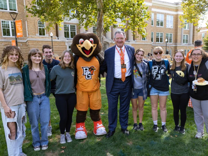 Group of students, President Rogers, and Freddie Falcon all together outside at the picnic. 