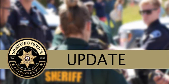 Graphic with the Jefferson County Sheriff’s Office logo on the left. The word ‘UPDATE’ appears in large black letters on a gold banner across the center. In the blurred background, law enforcement officers and vehicles are visible outdoors.