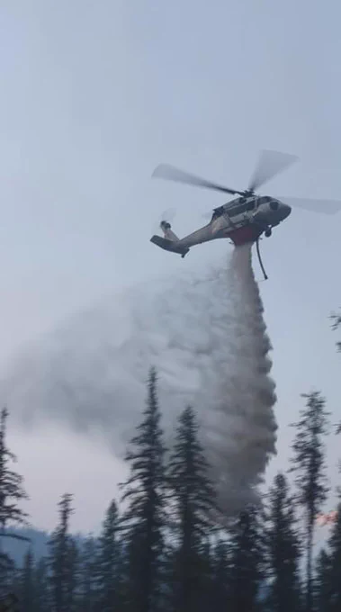 Fire helicopter makes a water drop on a forest fire.