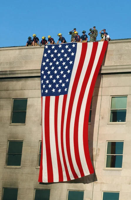 Photo credit: Soldiers from the 3rd Infantry render honors as firefighters and rescue workers unfurl an American flag at the Pentagon. (Photo by U.S. Navy Petty Officer 1st Class Michael Pendergrass)