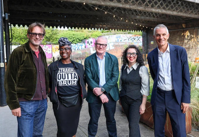 Photograph of five people (three men and two women) stood next to each other underneath a bridge.v