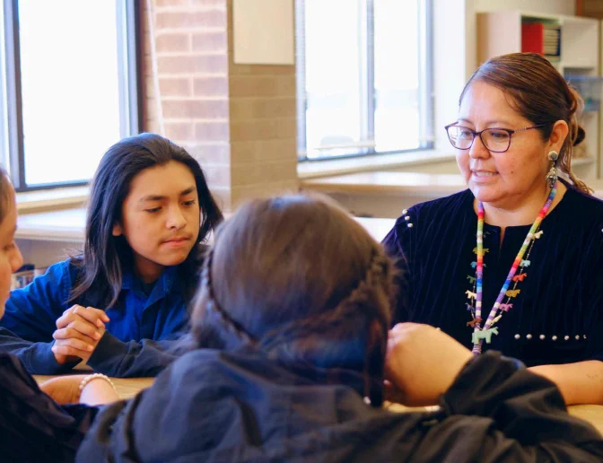 A group of students and a teacher engaged in a classroom discussion.