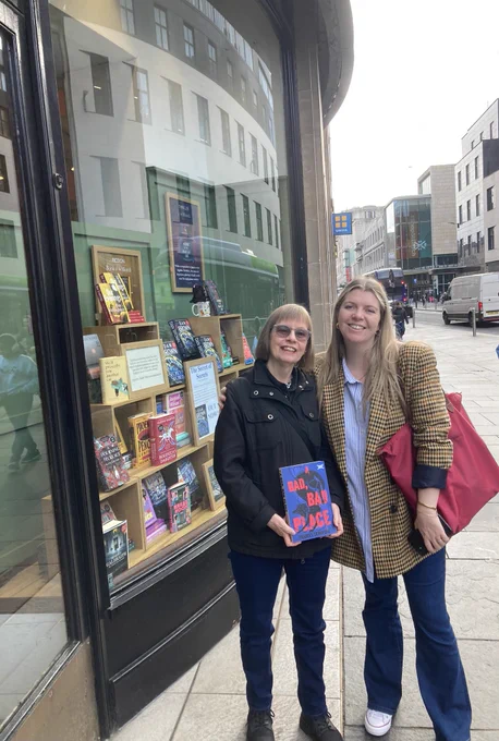 Frances and Becky outside bookshop holding copy of A Bad Bad Place