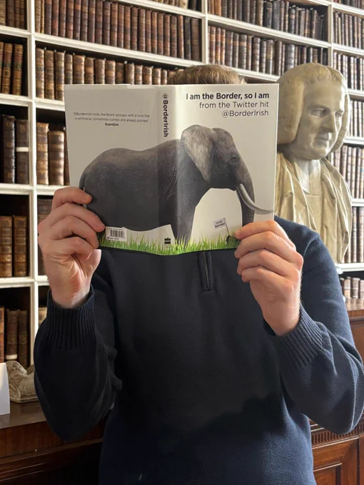 Photograph of a member of the CCBC Team reading 'I am the Border, so I am' - in Armagh Robinson Library. The Library's collections include over 40,000 printed works, 355 manuscripts, 4,100 museum objects and 7,300 archival items. Archbishop Richard Robinson founded the Library in the City of Armagh in 1771. He wanted to share his own collection of books and fine art with the general public.