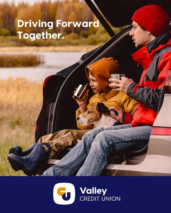 Family and dog sitting in the back of a car in the fall looking out over a river. With text that reads: Driving Forward Together