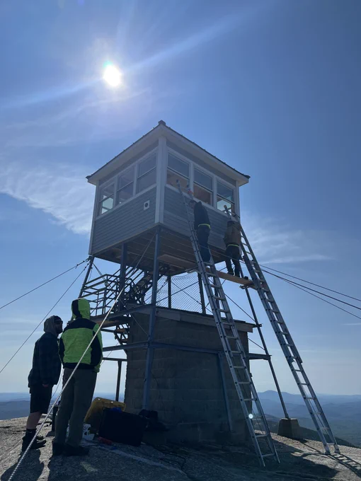 Cardigan Mtn. fire tower repairs - 2025-09-11 helicopter flight - crew inspecting cab