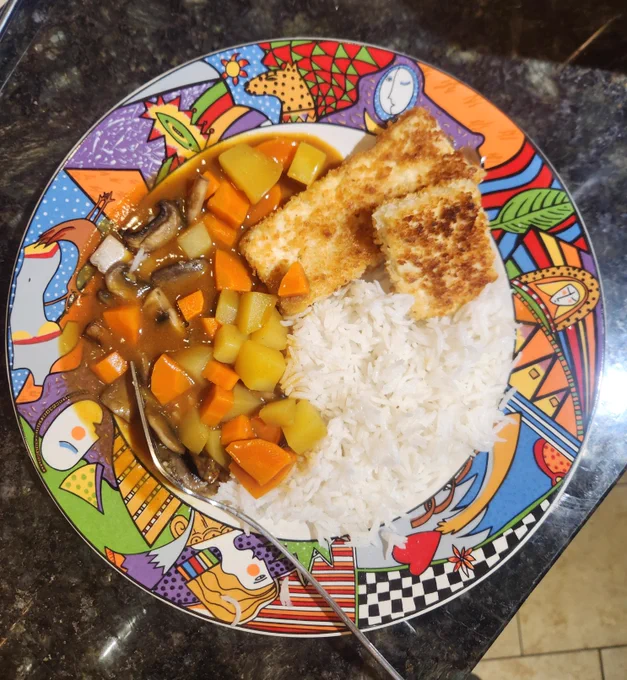 Colorful vintage plate with Japanese curried vegetables, basmati rice, and tofu katsu - a fried cutlet.