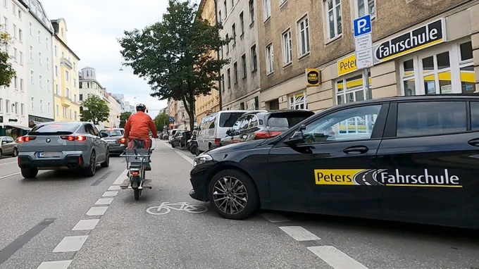 Fahrschulauto parkt vor Fahrschule auf Radweg