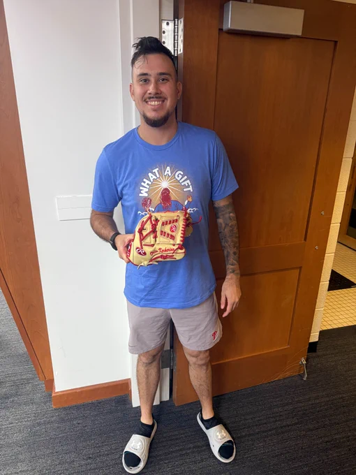Orion Kerkering smiles as he poses for a picture with his autographed glove. 