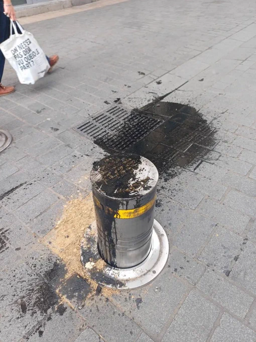 A rising bollard is covered in car oil after taking the insides from its victim.