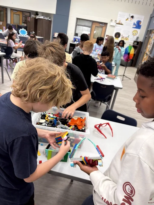 Three students building with Legos in the library. 