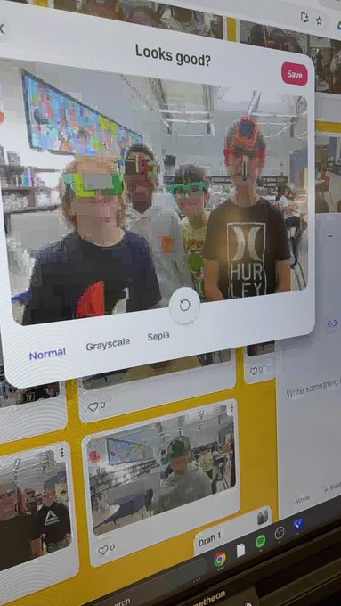 Four students in a library taking a picture on the laptop. 