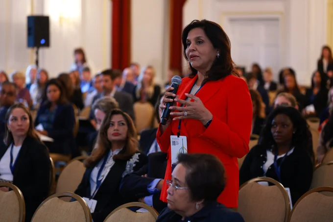 Woman stands up at microphone to ask a question during a breakout session at UNIFY