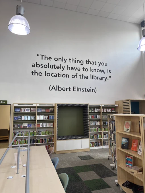 Photo of a wall of a library with a quote by Albert Einstein which reads "The only thing you absolutely have to know, is the location of the library"