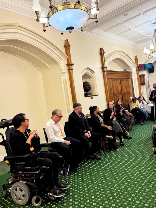 Panel discussion in the Churchill Room, Houses of Parliament, with James and Gáibhin seated beside Ria Patel while Michelle Anglesea listens speaks into a microphone alongside them.