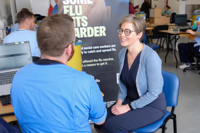  Dr Claire Cameron talking to a vaccinator about the flu vaccine.