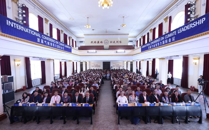Attendees seated in rows at the International Conference on Climate Leadership, with banners hanging above and speakers at the front table.