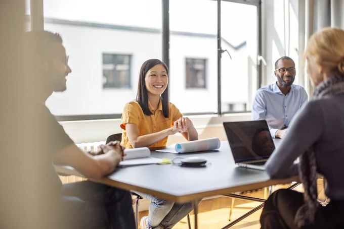 Four people seated around a table in an office setting