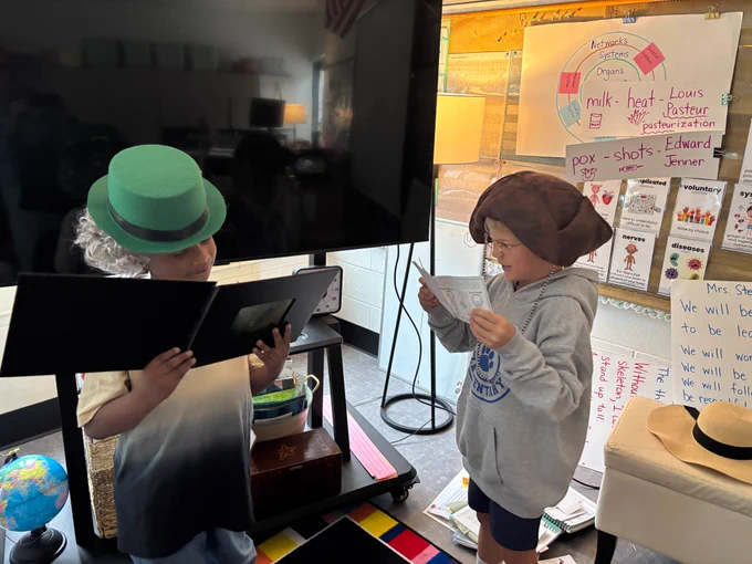 two first grade students reenact the signing of the constitution, outfits and all 