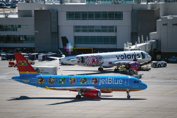 The Jetblue Super Mario-themed airplane taxis past the center of the concourse at DEN.