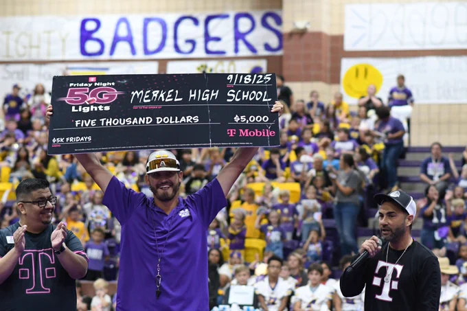 Picture of coach receiving the check from TMobile. 