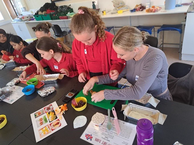 Pupils and a teacher working with food and information sheets.