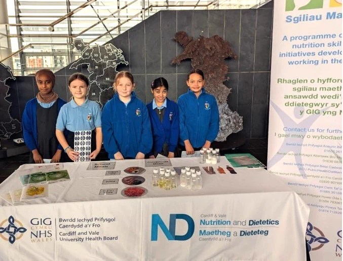 Five pupils stood together behind an information stand.