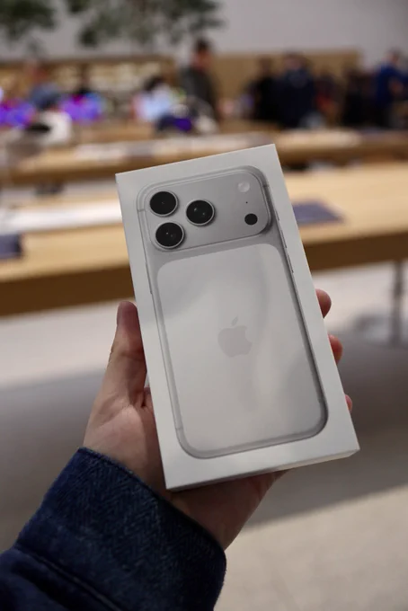 Silver iPhone 17 Pro box being held up at the Apple Store