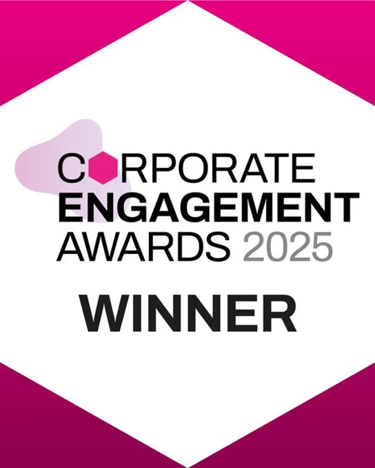Text reads, 'Corporate Engagement Awards 2025 Winner' on a white hexagon with pink accents in the corners and a pink spot above 'Corporate'.