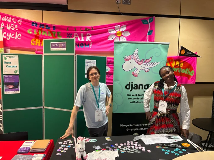Tom and Anna at the django booth, surrounding a banner with the django pony
