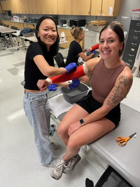 2 third year ot students practicing casting in lab