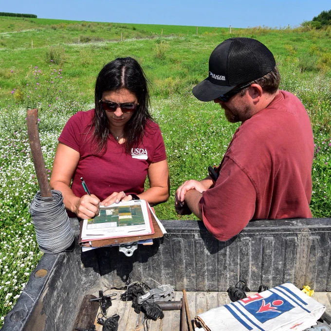 Two people working together to develop a plan while in a field
