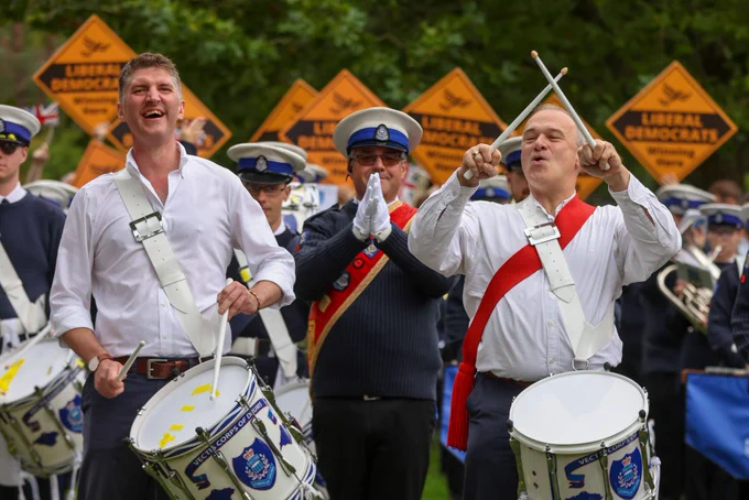Ed Davey and Edward Morello play drums together at a Liberal Democrat rally.