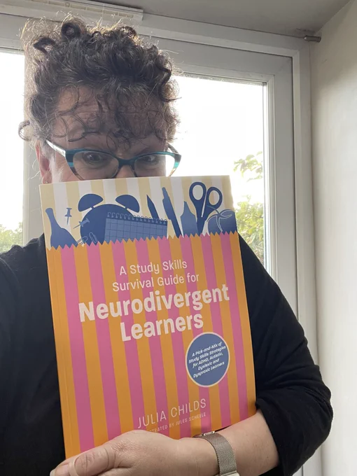 Me holding my book a study skills survival guide for neurodivergent learners