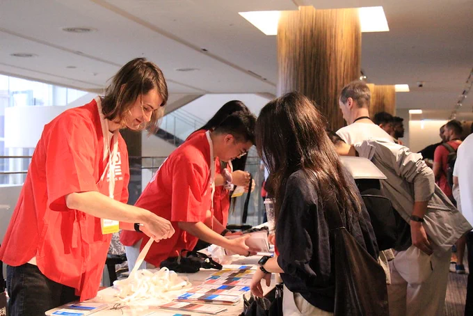 Student volunteers registering attendees at the desk.