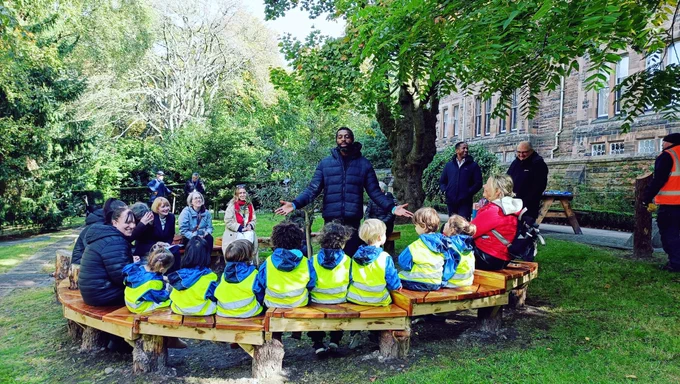 University of Glasgow colleagues and community around the peace bench and peace tree