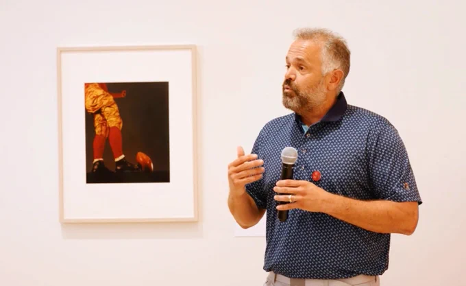 Husker head coach Matt Rhule is standing in front of a piece he chose as one of the co-curators of the Go Big Red exhibit. 