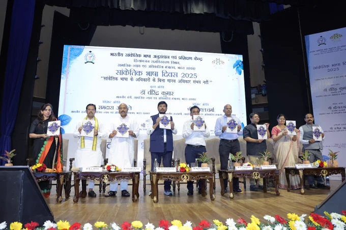 यह तस्वीर सांकेतिक भाषा दिवस के उपलक्ष्य में डॉ अंबेडकर इंटरनेशनल सेंटर में आयोजित कार्यक्रम की है। तस्वीर में सांकेतिक भाषा दिवस के उपलक्ष्य में केंद्रीय मंत्री डॉ वीरेंद्र कुमार, राज्य मंत्री श्री बी.एल वर्मा, राज्य मंत्री श्री रामदास अठावले व दिव्यांगजन सशक्तिकरण विभाग के सचिव श्री राजेश अग्रवाल द्वारा  ISLRTC की अर्धवार्षिक पत्रिका संकेत का विमोचन किया जा रहा है। 