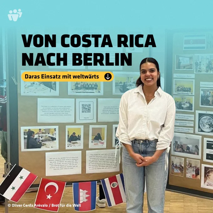 Eine junge Frau steht lächelnd vor einer Ausstellungstafel mit Fotos und Texten. Auf der Grafik steht: „Von Costa Rica nach Berlin – Daras Einsatz mit weltwärts.