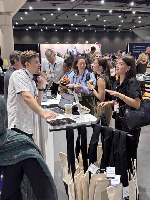 People engaging in conversation around the Acquia booth with laptops and coffee cups at Content Marketing World.