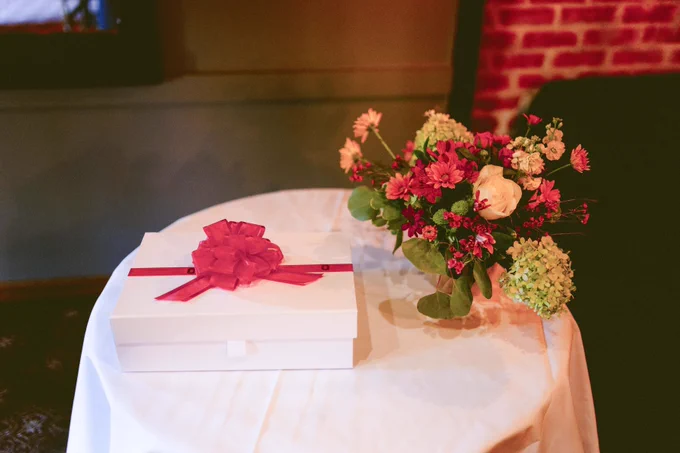 Dr. Tamiya's new white coat in box on a table with a bouquet of flowers