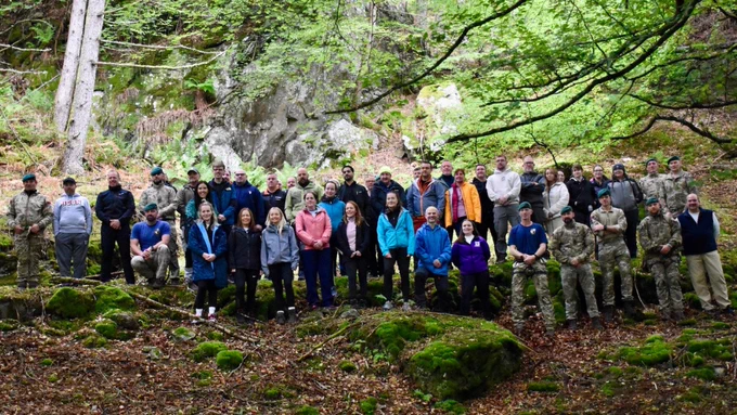 Nine uniformed Royal Marines Reservists and thirty-six people standing in a forest.